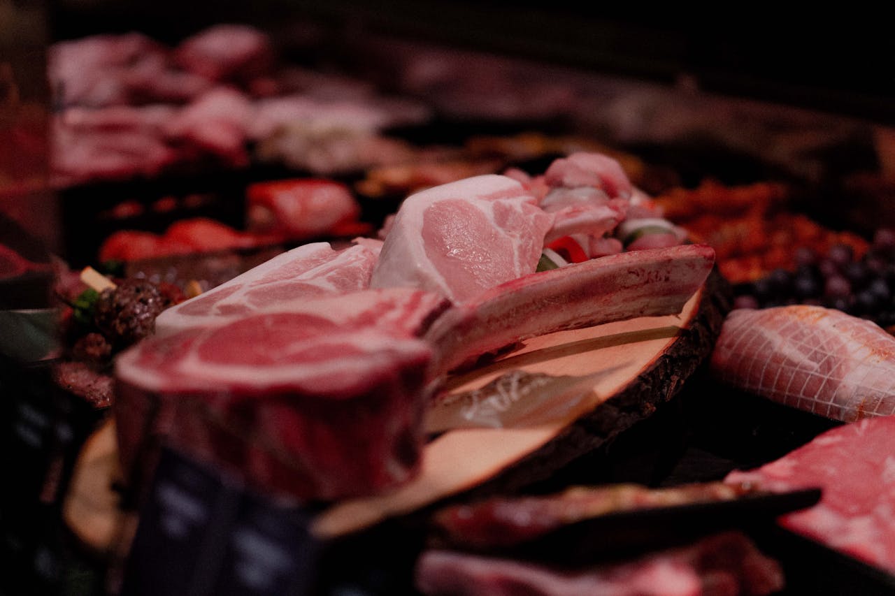 About Close-up of a variety of raw meats on display in a market setting, perfect for culinary and food industry themes.